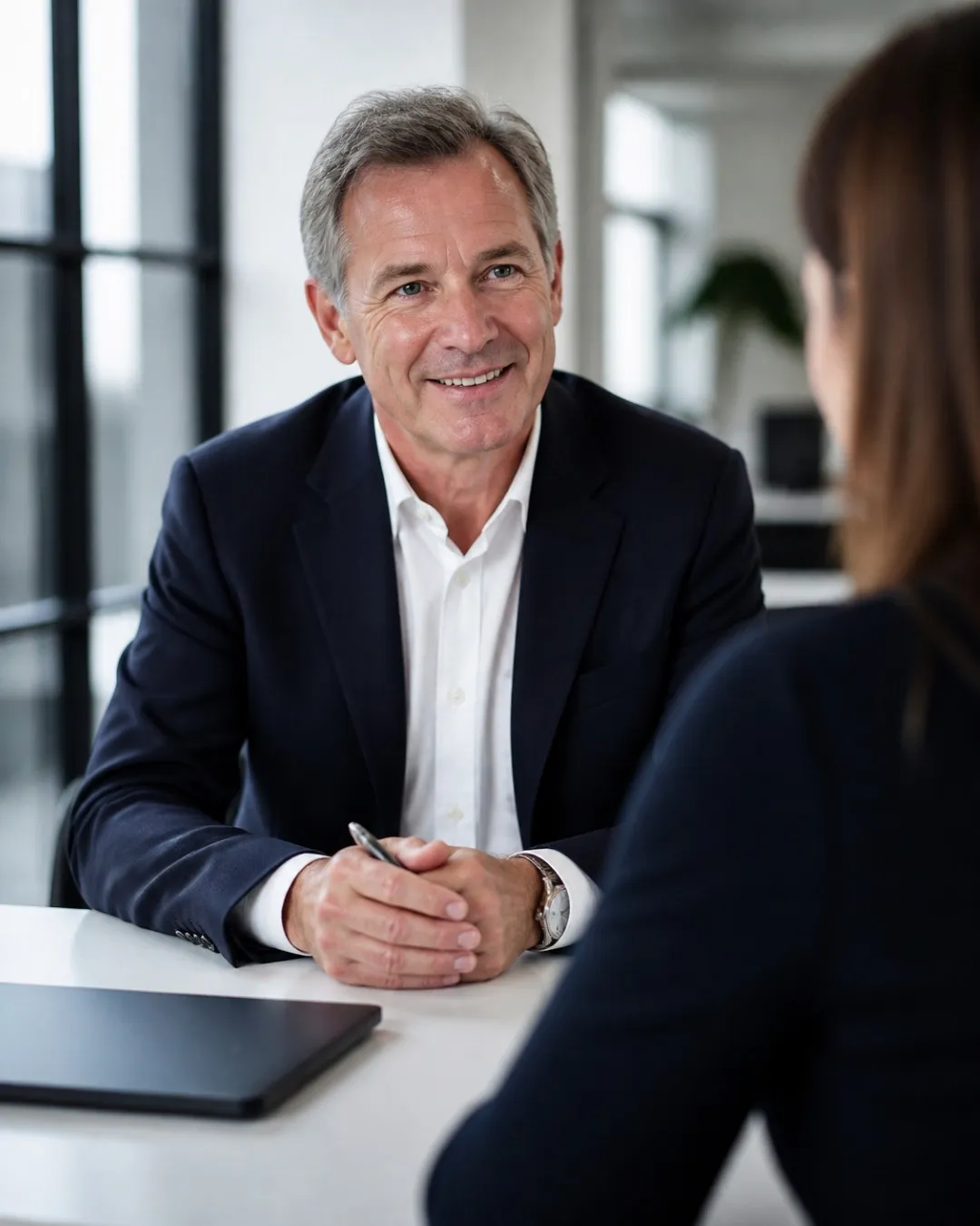 An accountancy practice owner greeting a client across his desk